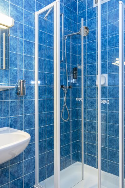 Dusche in einem blau gefliesten Badezimmer
