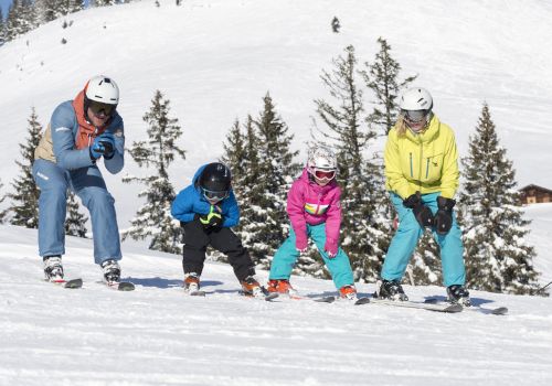 Familie mit Snowboards auf einer Skipiste