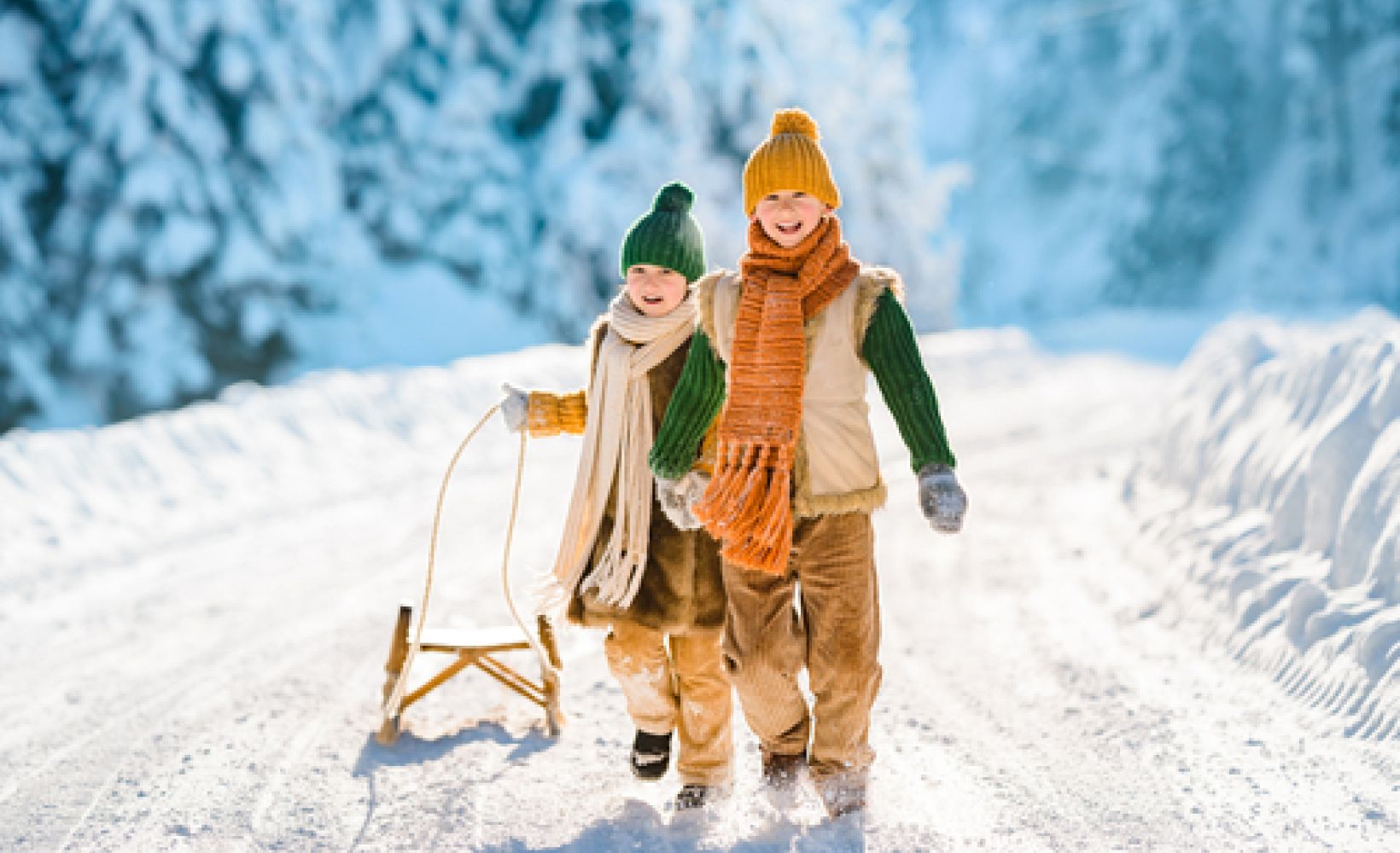 Zwei Kinder ziehen einen Schlitten durch den Schnee