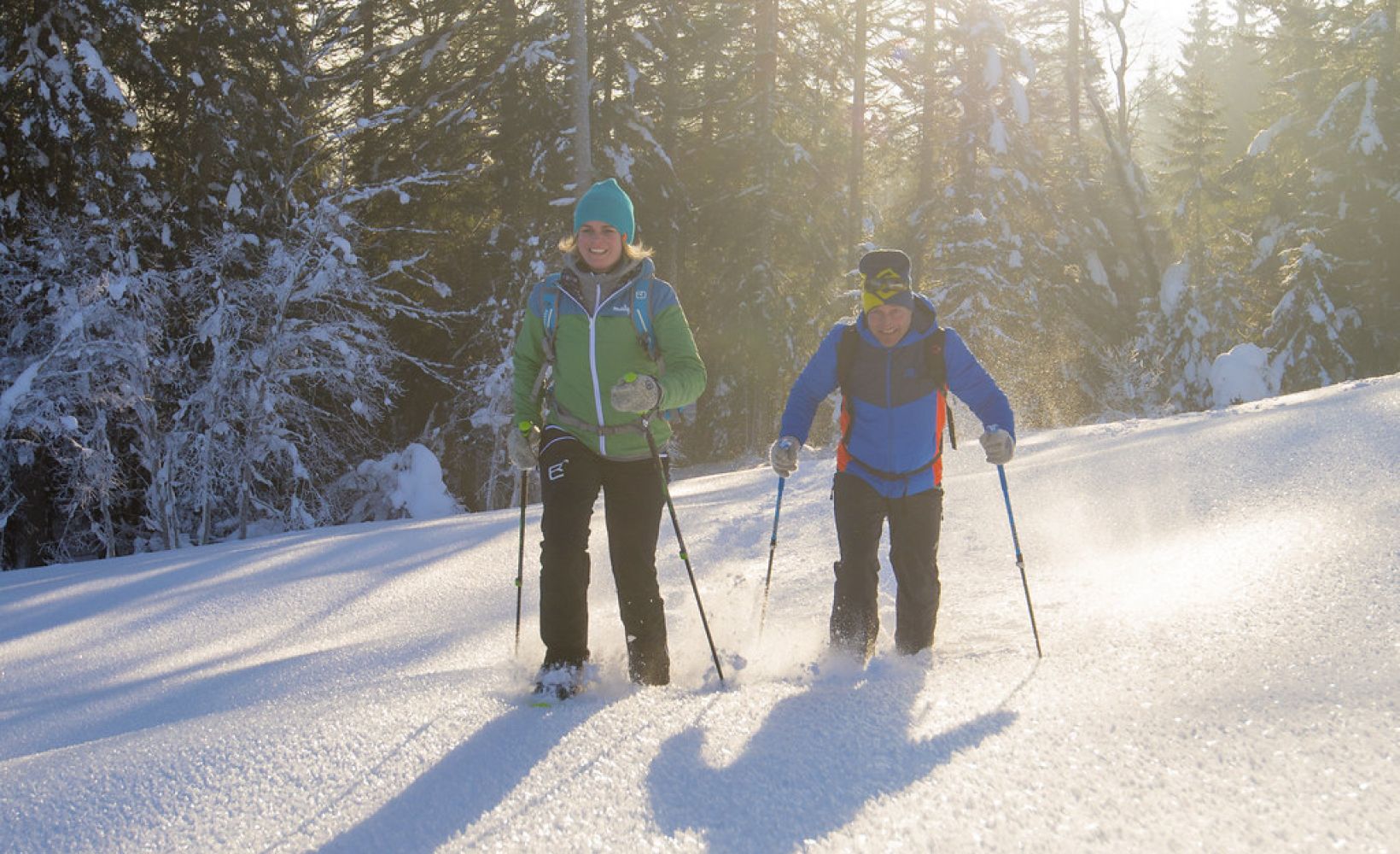Winterwanderer mit Stöcken am verschneiten Waldrand