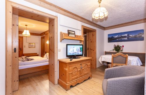 Wohnbereich mit Fernseher und Durchgang zum Schlafzimmer
