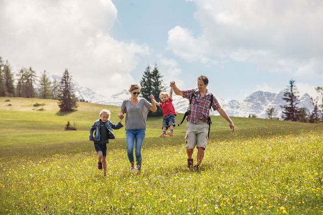 Familie beim Wandern auf einer Bergwiese
