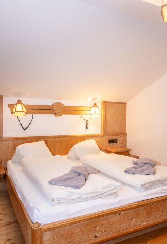 Doppelzimmer mit Holzmöbeln und Wandleuchten